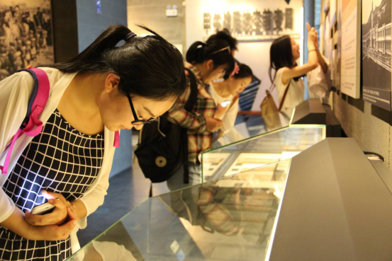 (党支部成员在展厅里仔细观看陈列文物。/摄影:崔慧莹)